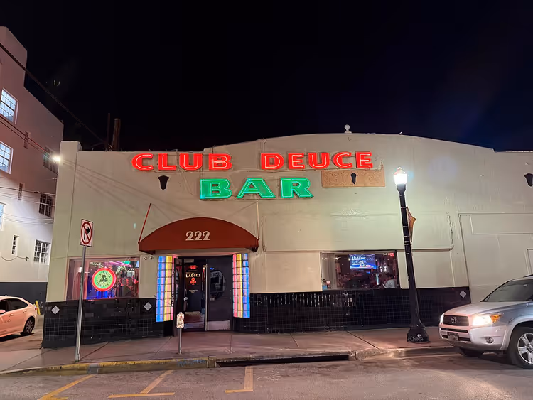 Façade nocturne du bar Club Deuce avec enseigne au néon