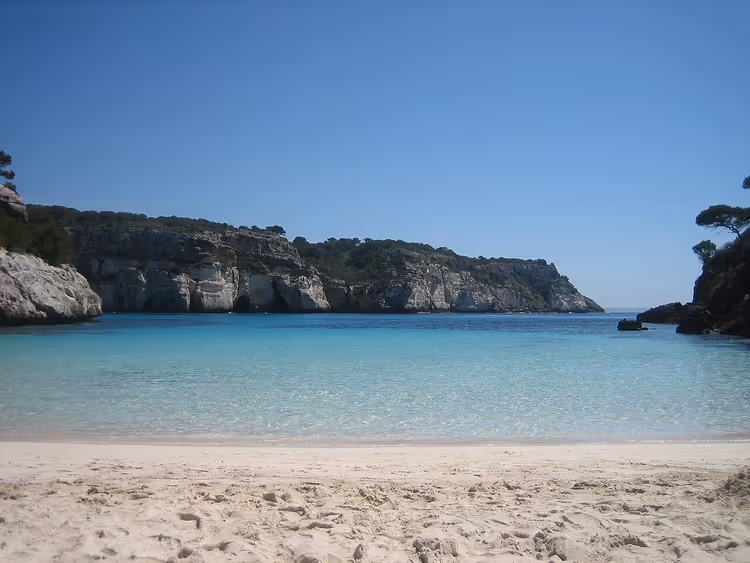 Stranden Cala Macarelleta med turkis vann og klipper