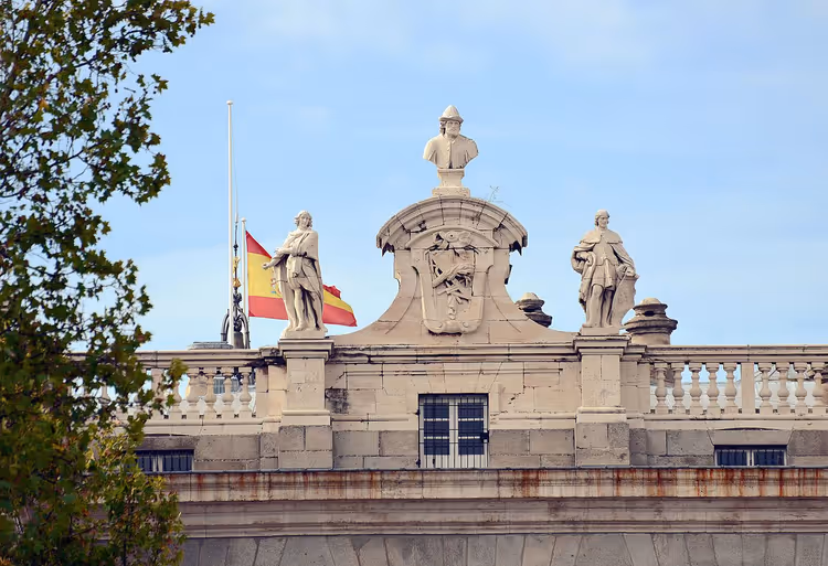 Historisk bygning med våpenskjold og statuer i Madrid