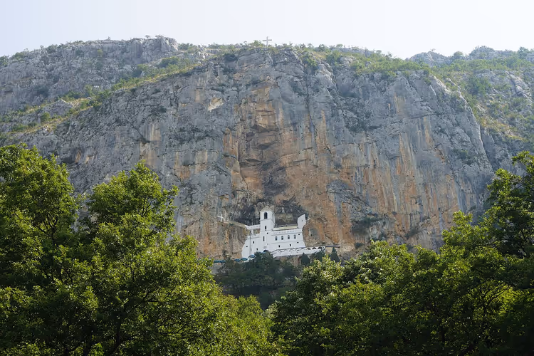 Kloster Ostrog, in eine steile Felswand über dem Wald gebaut