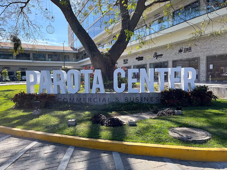 Alışveriş merkezinin yanındaki çimende Parota Center tabelası