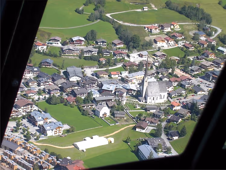 Flyfoto av landsbyen Maria Alm med kirke og hus
