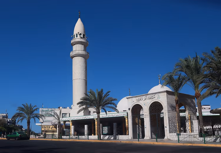 Witte moskee met minaret en palmbomen in Aqaba