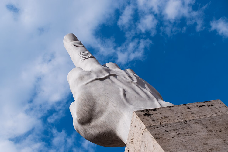 Marmorskulptur av en løftet hånd mot himmelen