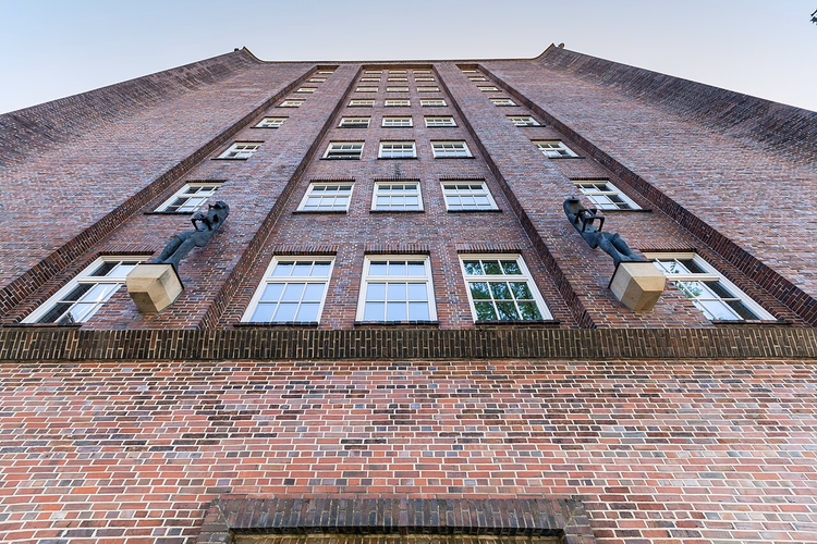 Teglsteinsfasaden til Messberghof med skulpturer, sett nedenfra