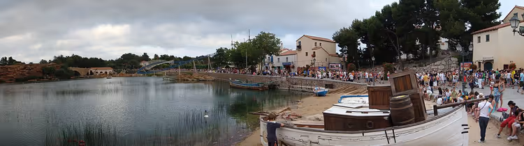 Lagün ve gezinti yolunda kalabalık olan bir Akdeniz kasabasının panoraması
