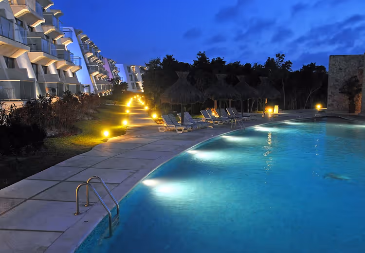 Nachtelijk zwembad en gebouwen bij Grand Sirenis Resort