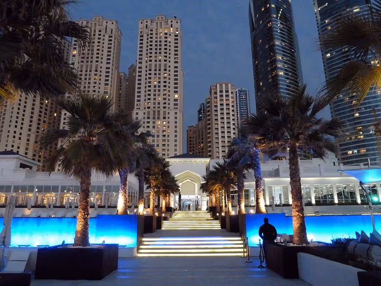Nachtelijke entree van een beachclub tussen de wolkenkrabbers van Dubai