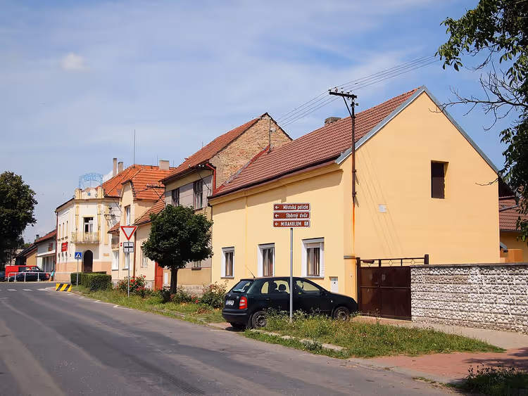 Straat in Milovice met een geel huis en een auto