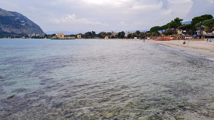 Helder water en zandstrand van Mondello