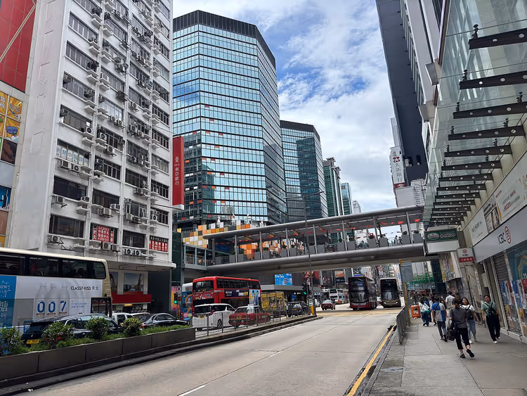 Voetgangersbrug en bussen in een straat in Mong Kok, Hong Kong