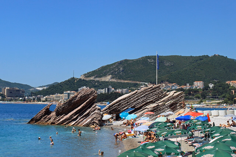 Gelaagde rotsen en parasols bij Rafailovići Beach