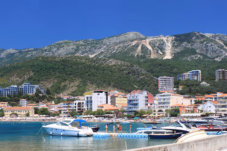 Panorama van Rafailovići met strand, boten en bergen