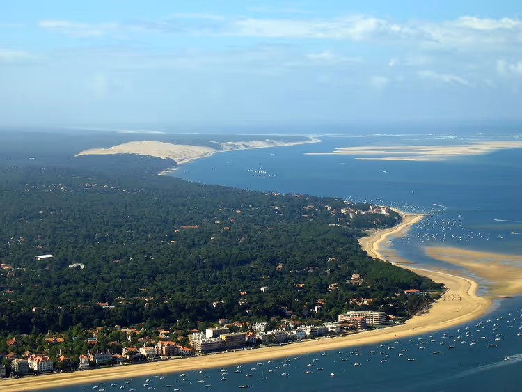 Panorama van de baai van Arcachon met strand, dennenbomen en boten
