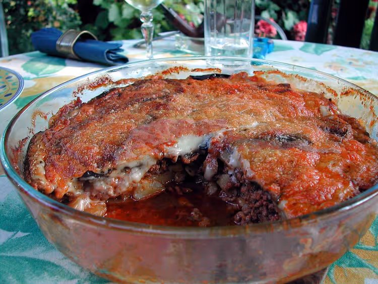 Gratinert moussaka i en ildfast form på et bord