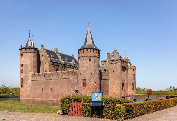 Muiderslot av rød murstein med tårn ved vollgraven