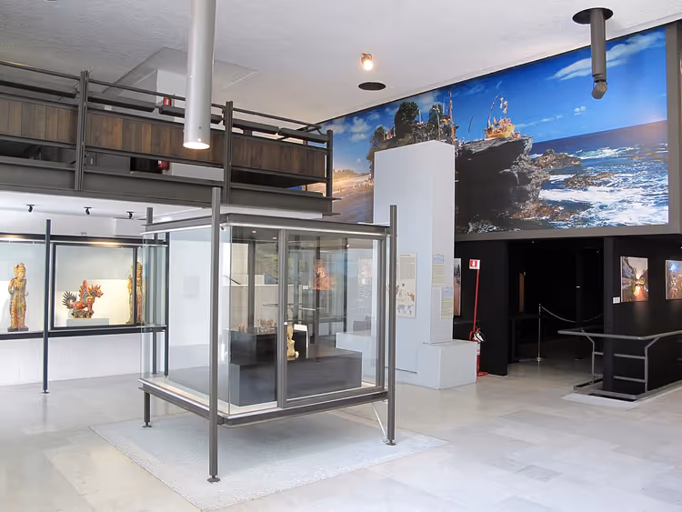 Museumsal med montre og et panoramabilde på veggen