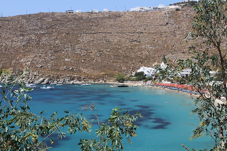 Psarou Beach met parasols en turquoise water