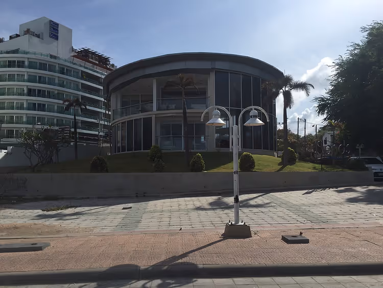 Wit hotelgebouw Royal Beach View met een glazen paviljoen