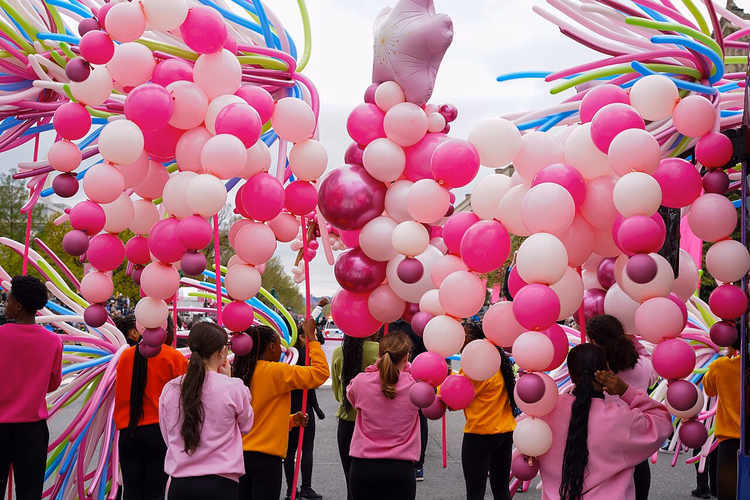 Paradeteilnehmer mit rosa Luftballons