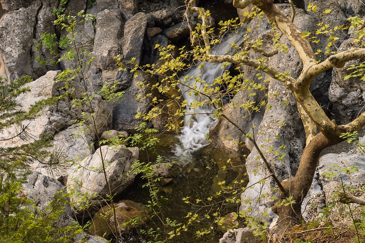 Waterval tussen rotsen en bomen op Evia