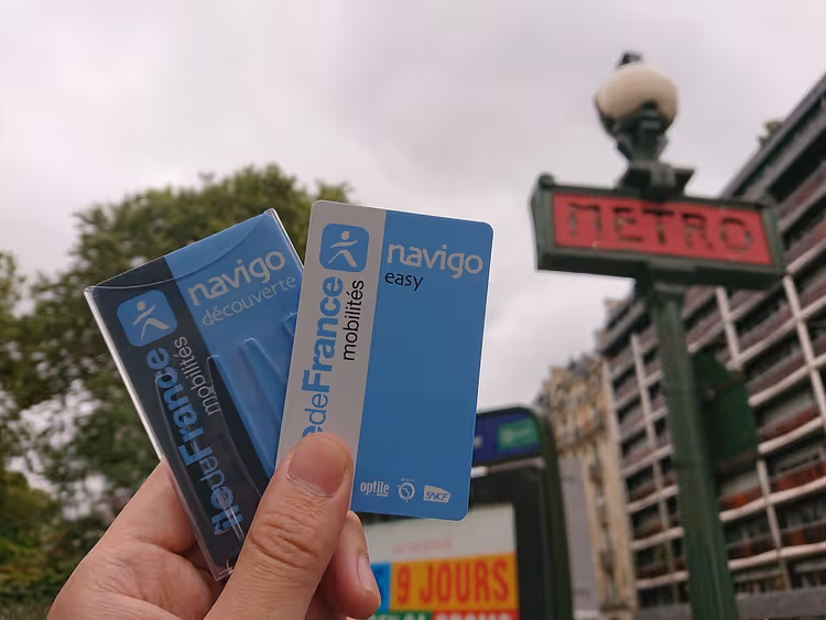 Navigo Easy-kaart in de hand met de Parijse metro op de achtergrond