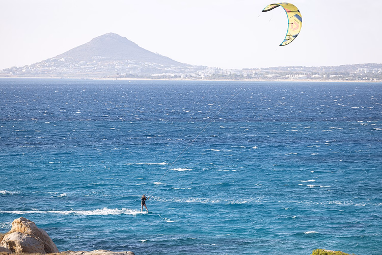 Kitesurfer på det vindfulle havet utenfor Naxos