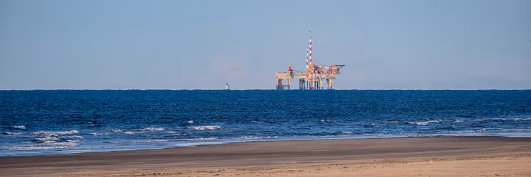 Sandstrand auf Ameland und die Nordsee mit einer Plattform