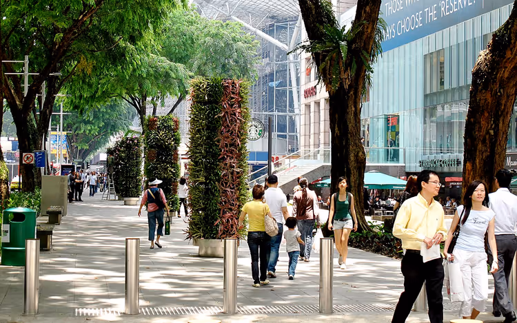 Yeşil sütunlar ve insanlarla Orchard Road yaya geçidi
