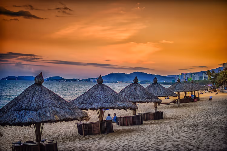 Rieten parasols op Nha Trang Beach bij zonsondergang