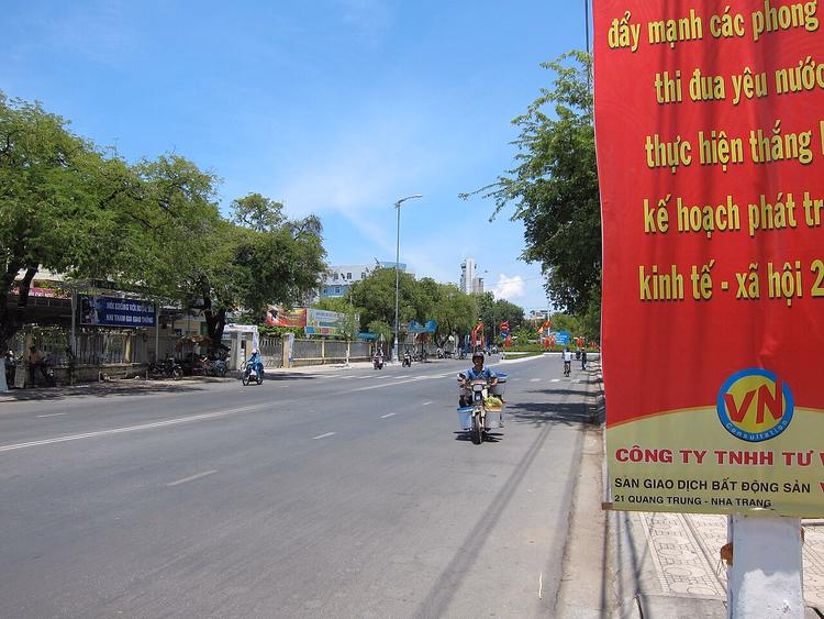 Gate i Nha Trang med motorsykler og et rødt banner