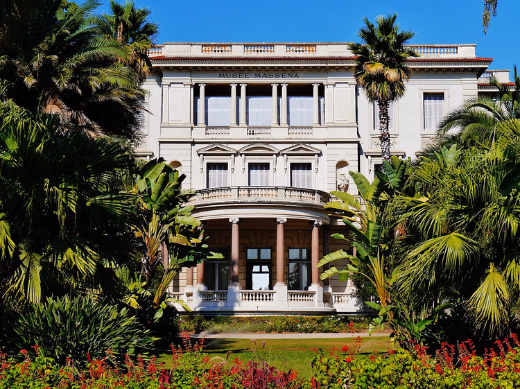 Fasaden til Villa Massena blant palmene i hagen