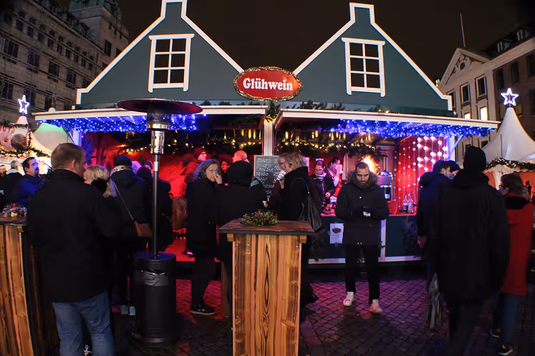 Weihnachtsmarkt am Abend mit einem Stand und Besuchern