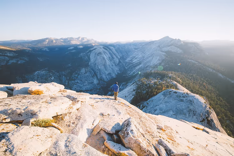 Wanderer auf der Kante des Granitdoms Half Dome über dem Tal