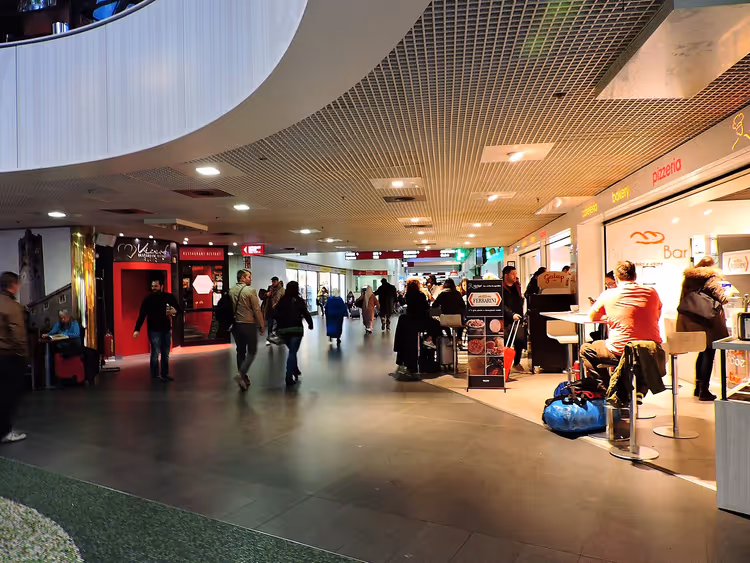 Flughafen-Terminal mit Passagieren und Geschäften