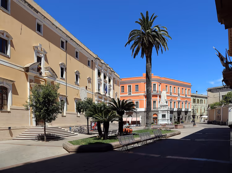 Oristano'da palmiyeler ve tarihi binalarla Piazza Eleonora