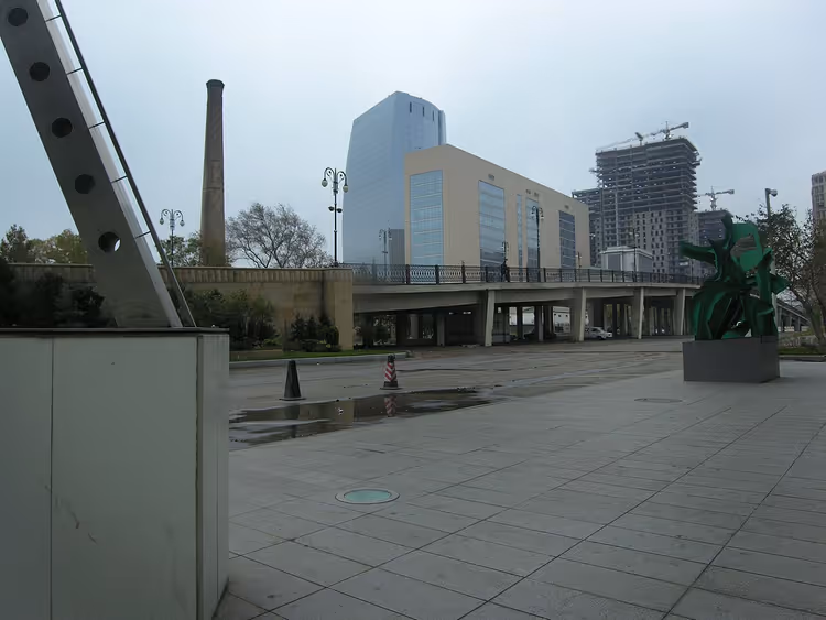 Plein met een modern gebouw en een groen sculptuur