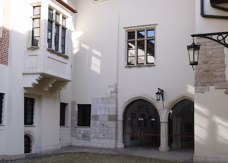 Witte binnenplaats met arcades en een balkon