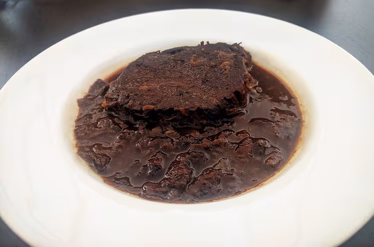 Pašticada, braised beef in dark sauce on a plate
