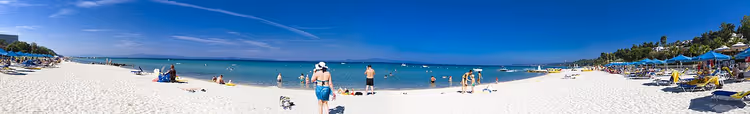 Panorama van een zandstrand met vakantiegangers aan zee