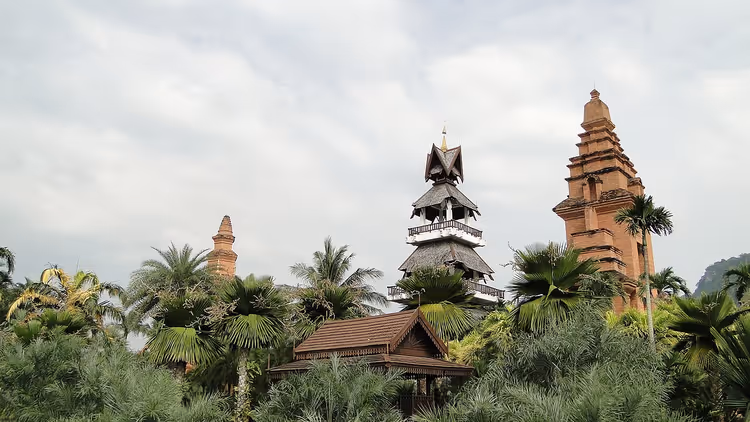 Tayland kuleleri ve bir köşk ile palmiye bahçesi