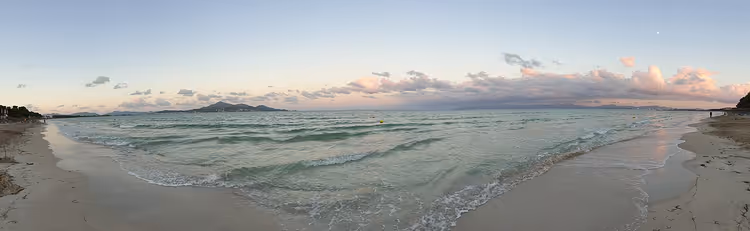 Panoramautsikt over Playa de Muro med havet i solnedgang