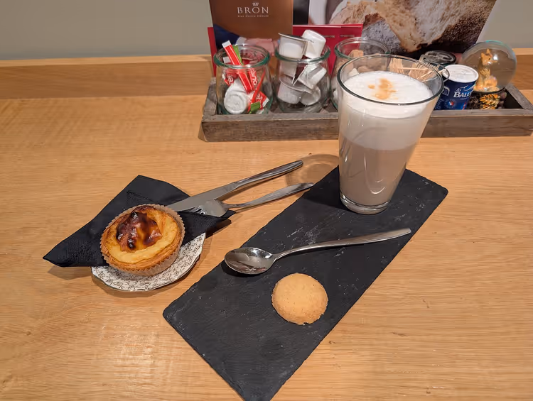 Pastel de nata und Latte macchiato auf einem Tisch