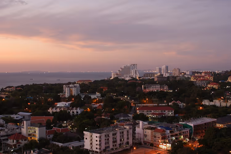 Avondpanorama van Pattaya: zee, stadslichten en gebouwen