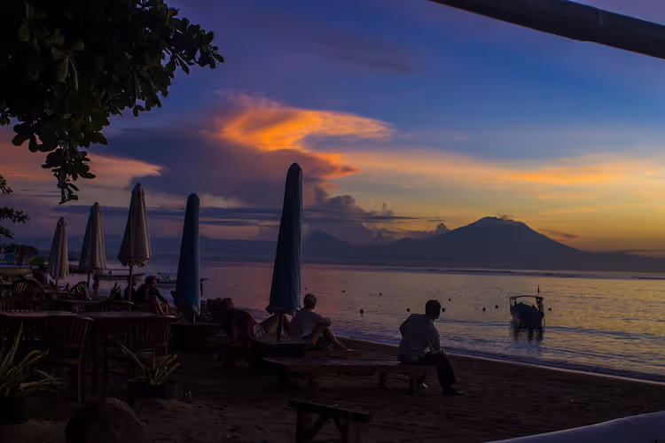 Sanur Beach met ligstoelen en parasols in de schemering