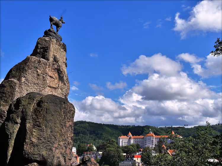 Karlovy Vary'nin üzerinde dağ keçisi heykelli kaya