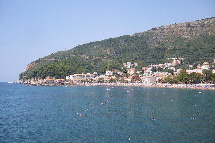 Petrovac-bukta med strand og grønn ås