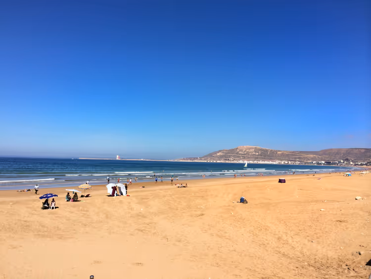 Şemsiyeler ve okyanusla Agadir kumsalı