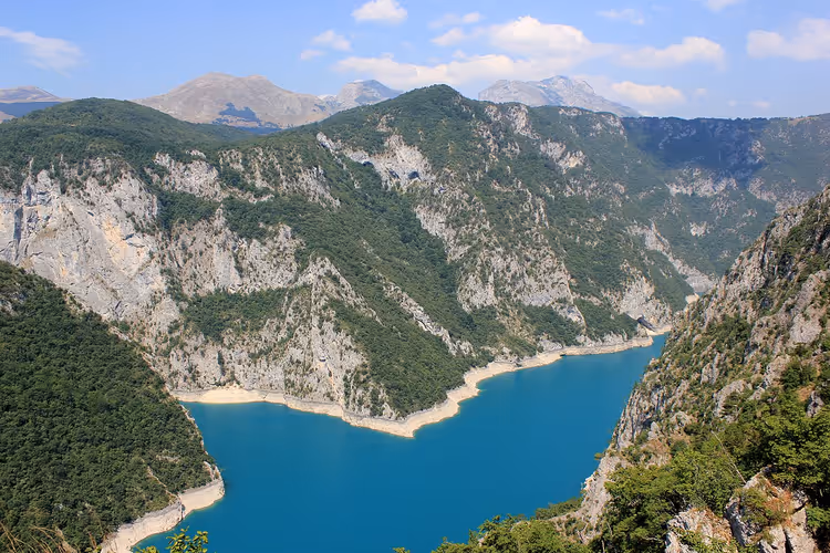 Turquoise bergmeer omringd door groene bergen