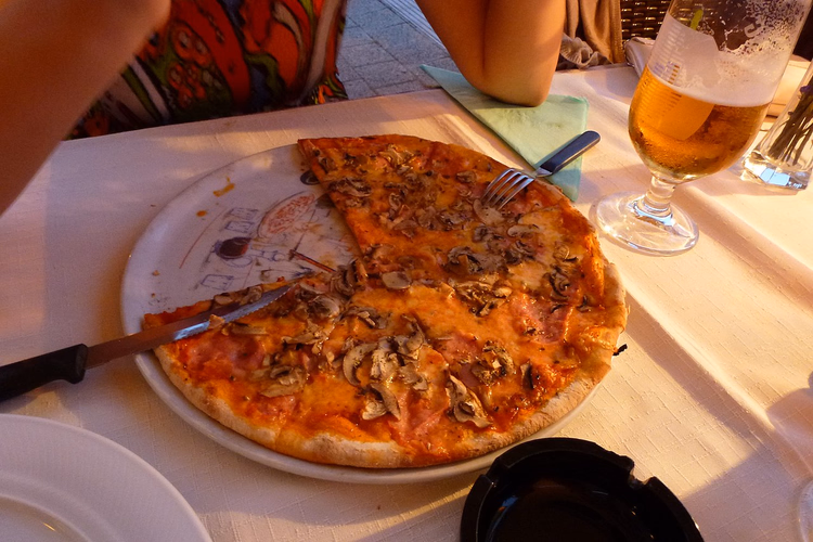 Capricciosa pizza with mushrooms and a glass of beer